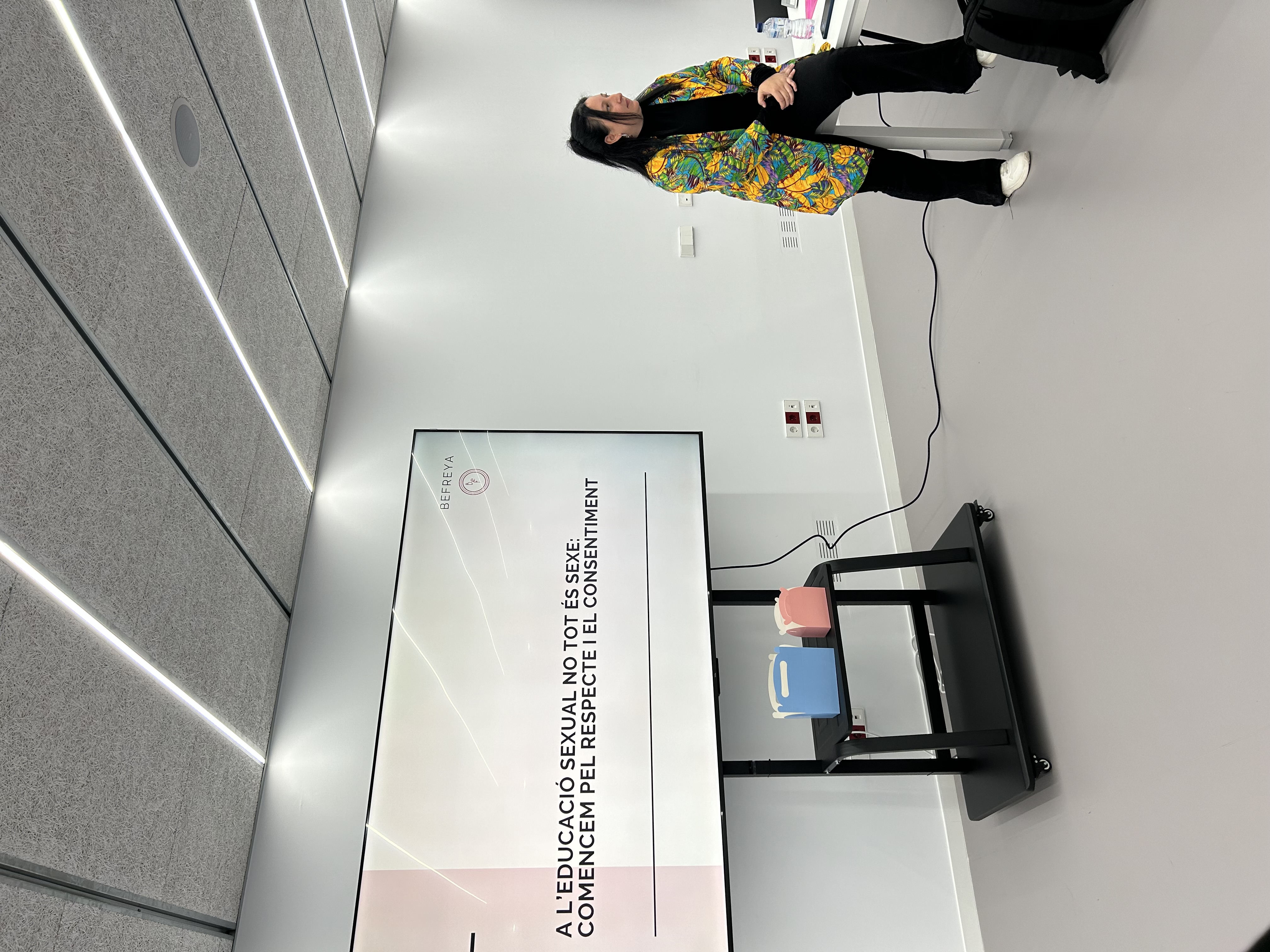 Educadora de BeFreya presentant davant una pantalla gran amb la diapositiva 'A l'educació sexual no tot és sexe'