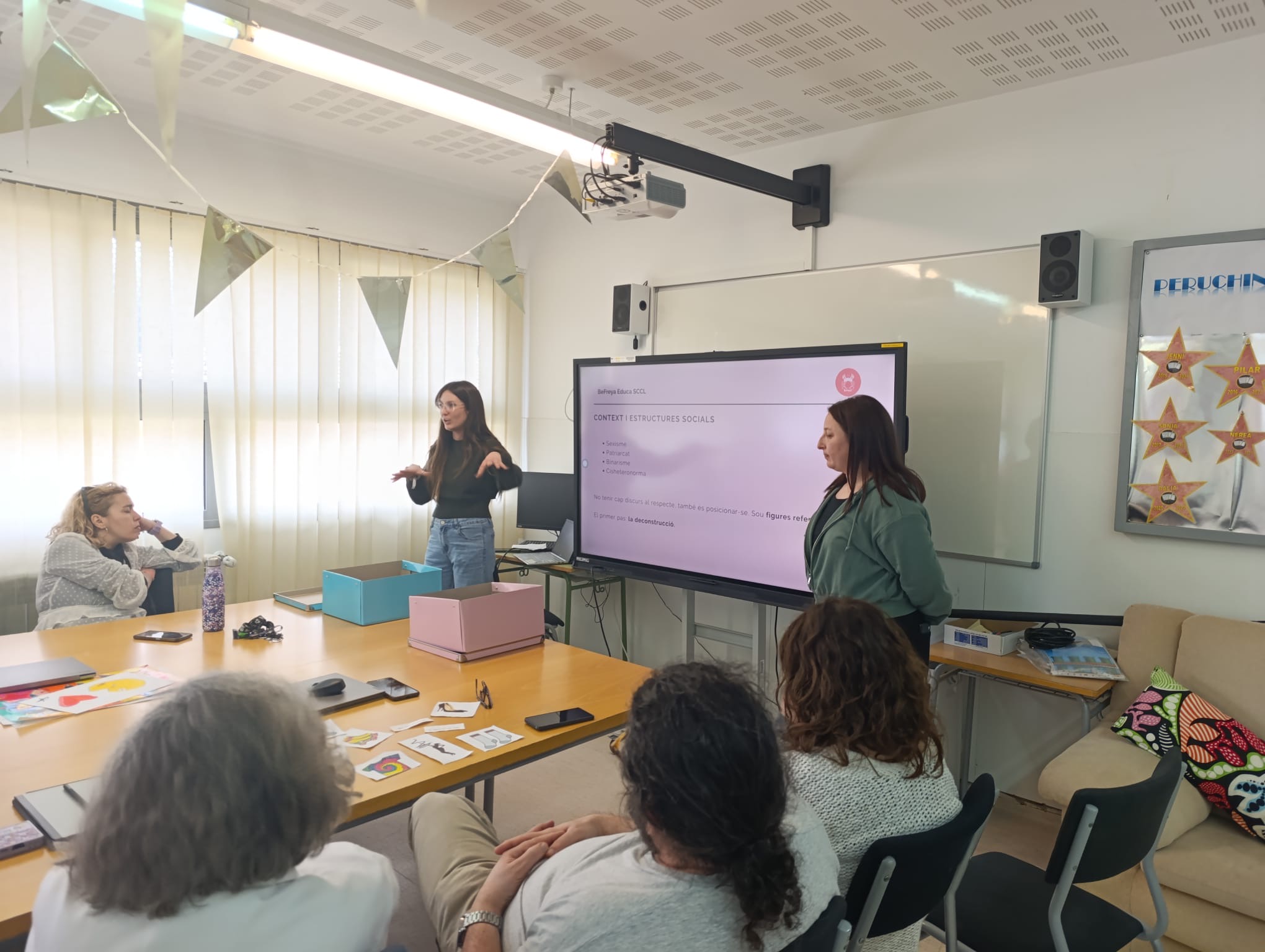 Educadora de BeFreya presentant amb tauleta davant un grup d'alumnes, xerrada participativa